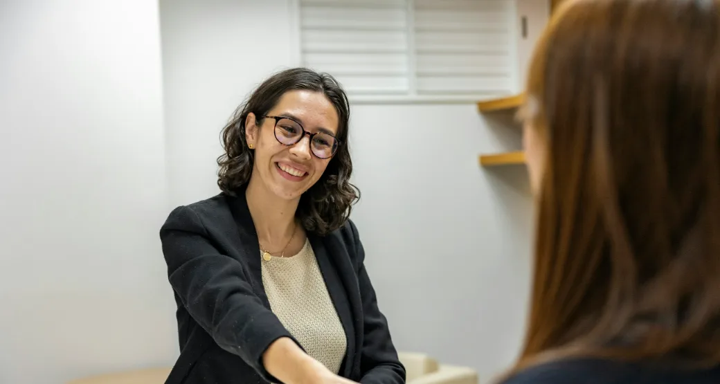 A smiling professional shakes hands at a business meeting