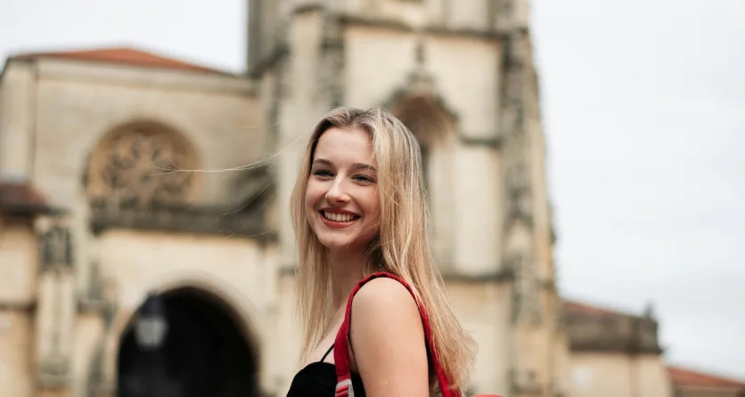 A smiling student with a backpack on campus