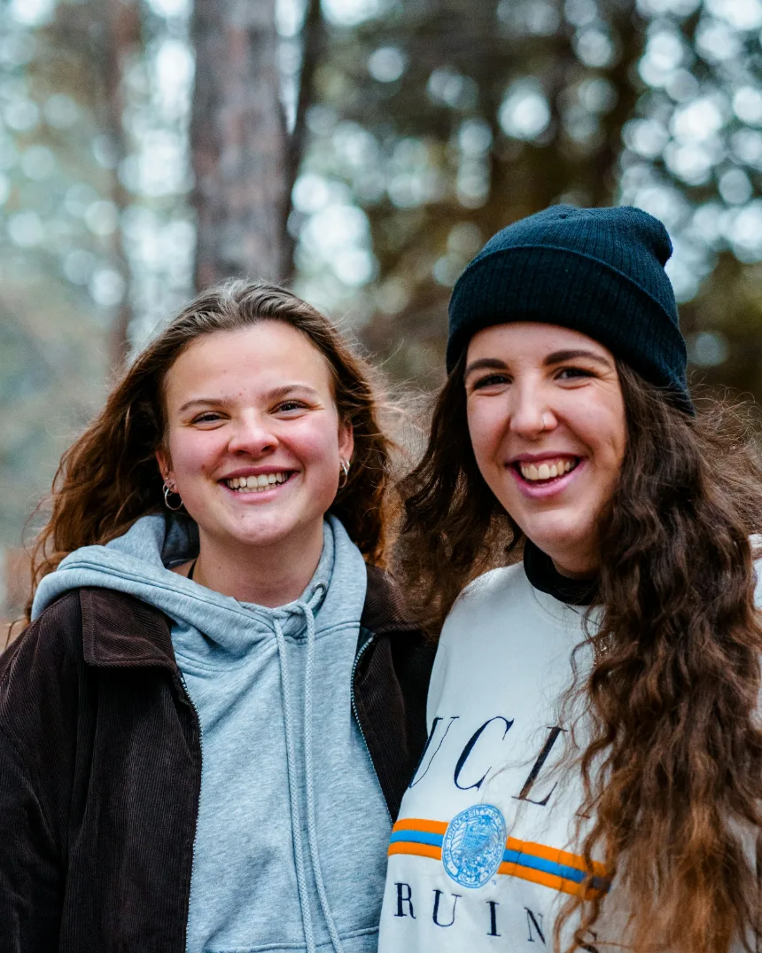 Two students smile together outdoors
