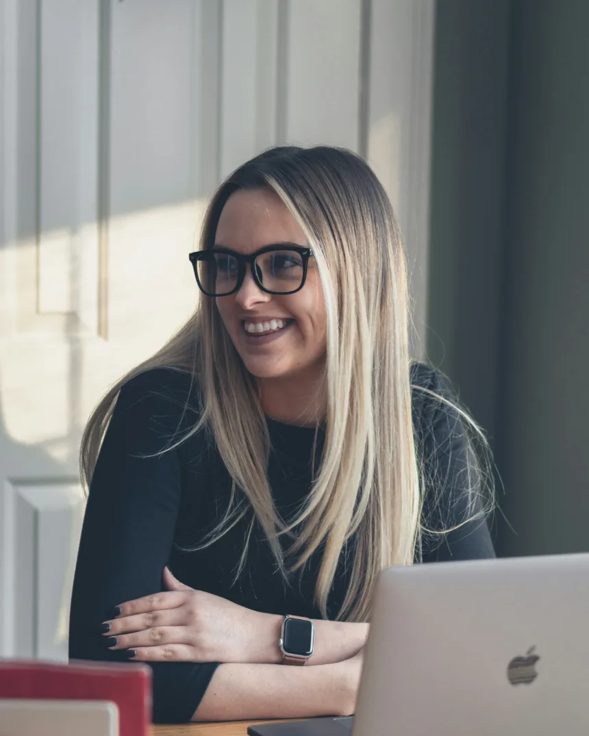 A smiling student working on a laptop